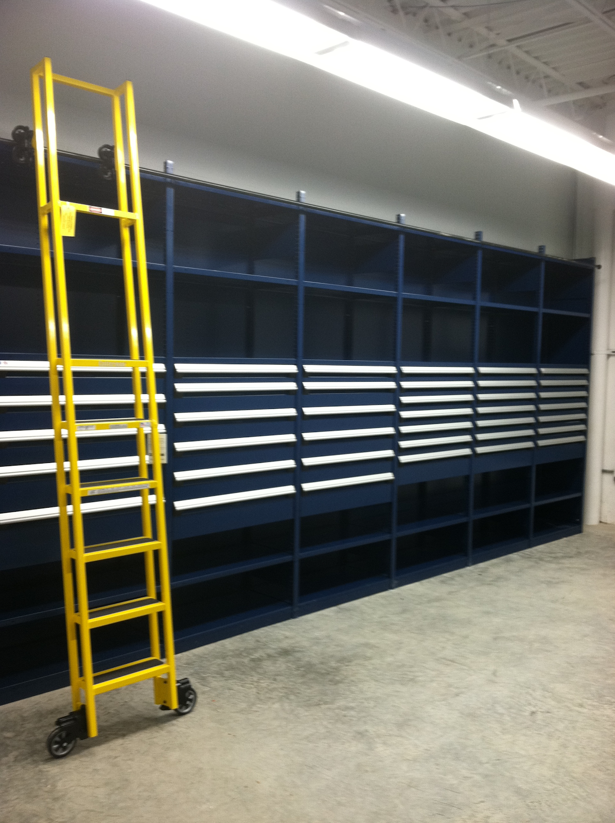 High-rise warehouse shelving with drawers and mobile ladder